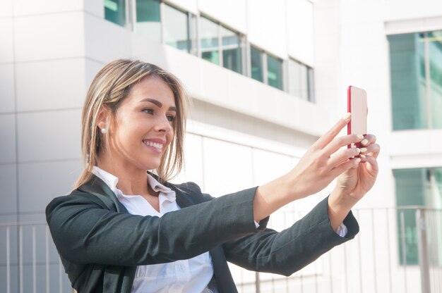 Femme d'affaires heureux parler selfie photo en plein air