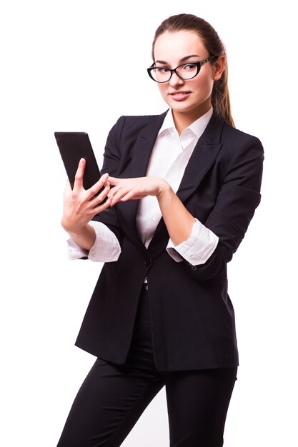 Femme d'affaires jeune, confiante, réussie et belle avec l'ordinateur tablette isolé sur un mur blanc