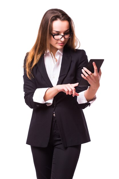 Femme d'affaires jeune, confiante, réussie et belle avec l'ordinateur tablette isolé sur un mur blanc