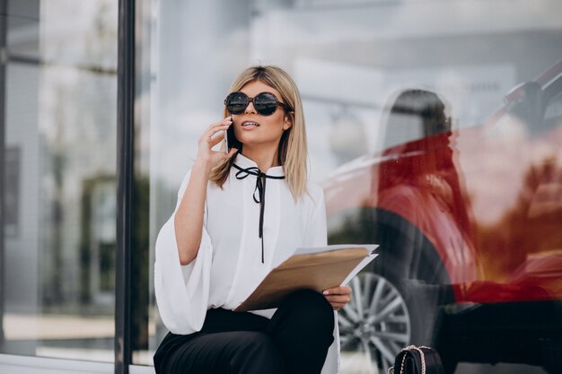 Femme d'affaires jeune parler au téléphone et lire des documents