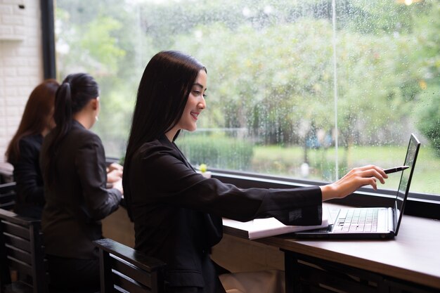 Femme d&#39;affaires jeune travaille sur ordinateur portable au bureau
