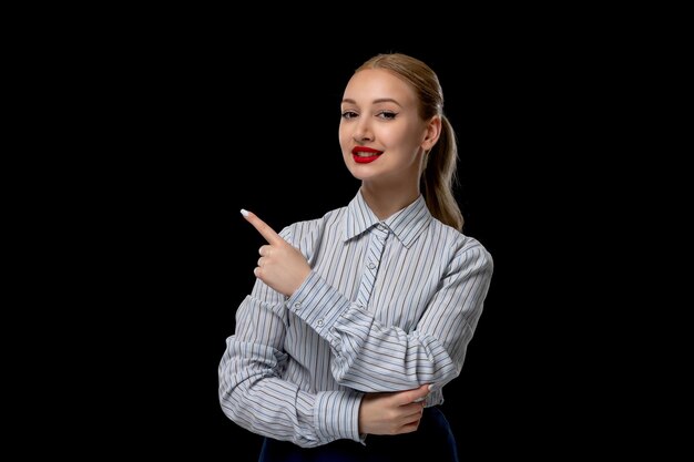 Femme d'affaires jolie fille souriante pointant vers la gauche avec du rouge à lèvres en tenue de bureau