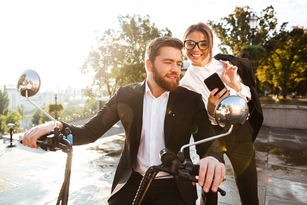 Femme d'affaires joyeuse debout près d'un homme barbu en costume