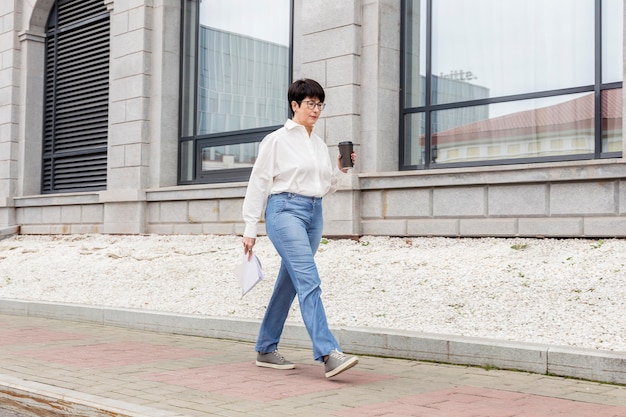 Femme d'affaires marchant avec un café à la main