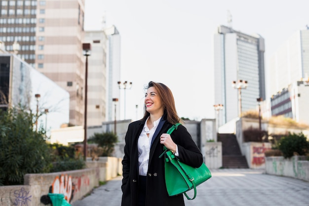 Femme d&#39;affaires marchant dans la rue avec sac