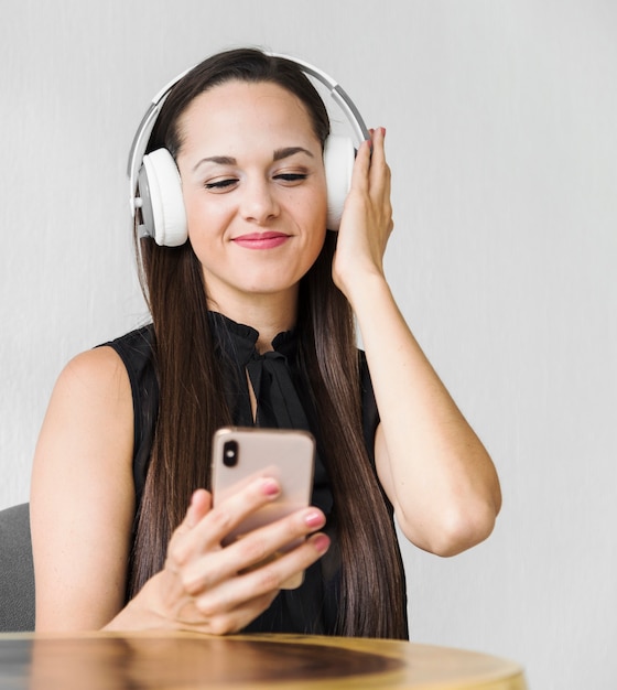 Femme d&#39;affaires moyen tirant de la musique sur des écouteurs