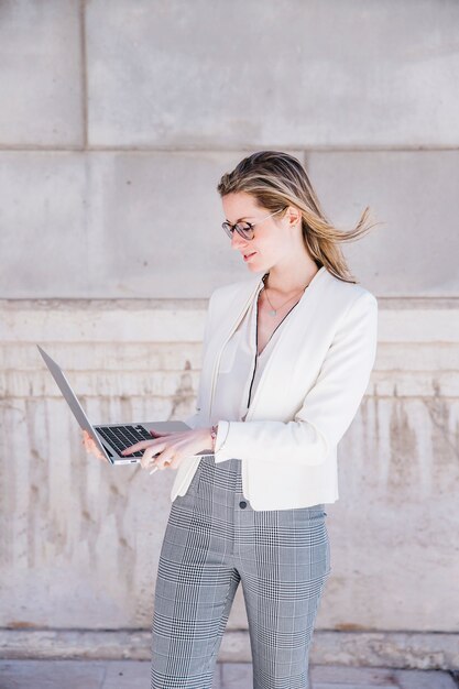 Femme d&#39;affaires avec ordinateur portable dans la rue