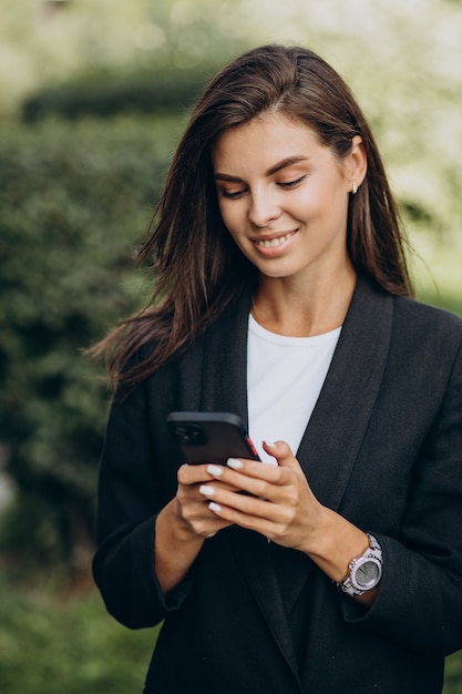 Femme d'affaires parlant au téléphone dans le parc