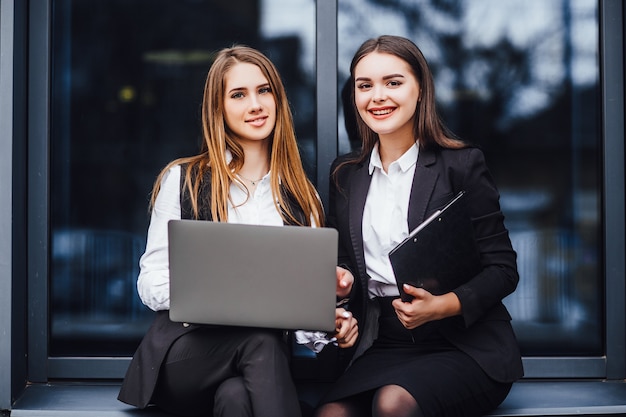 Femme d'affaires parlant pour un plan d'affaires tout en étant assis sur un ordinateur portable ! Près du centre de bureaux! Vie réussie!