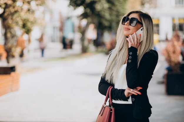 Femme affaires, parler téléphone, dans rue