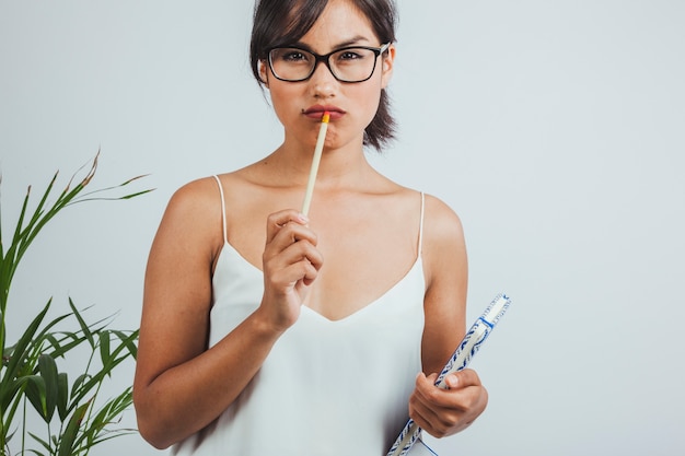 Femme d&#39;affaires pensant avec un crayon sur ses lèvres