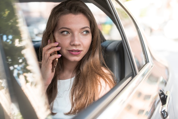 Femme d&#39;affaires posant à l&#39;intérieur d&#39;une voiture