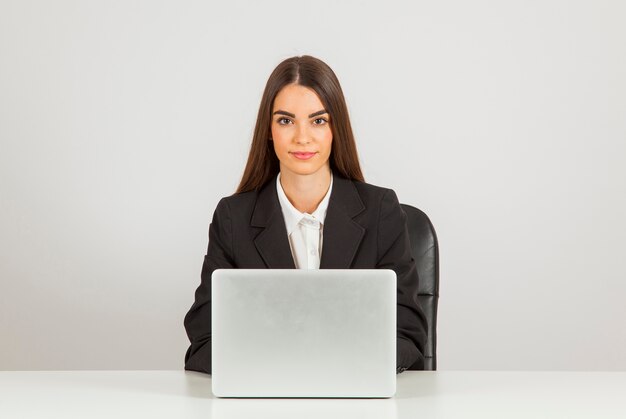 Femme d&#39;affaires posant avec un ordinateur portable