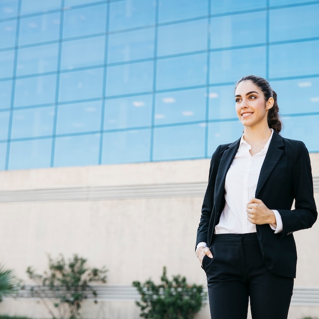 Photo gratuite femme d'affaires professionnelle devant le bâtiment