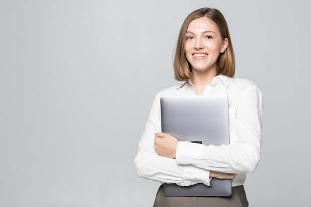 Femme d'affaires prospère tenant un ordinateur portable sur blanc