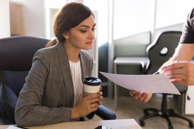 Femme d'affaires à la recherche de papiers au bureau