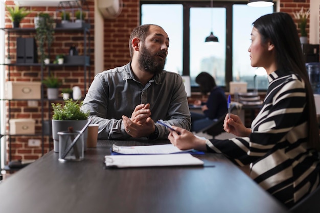 Femme d'affaires recrutant un employeur posant des questions sur le cv lors d'une réunion d'entretien dans un bureau d'affaires de démarrage. Directeur exécutif embauche candidat discutant de l'offre d'emploi des ressources humaines. Notion d'embauche