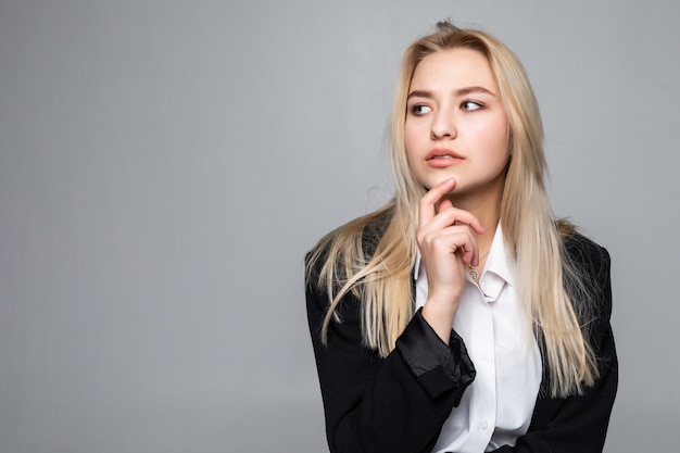 Femme d'affaires réfléchie avec un doigt sous le menton à la recherche d'isolement.