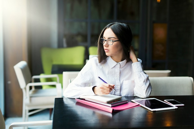 Femme d&#39;affaires en regardant loin au café