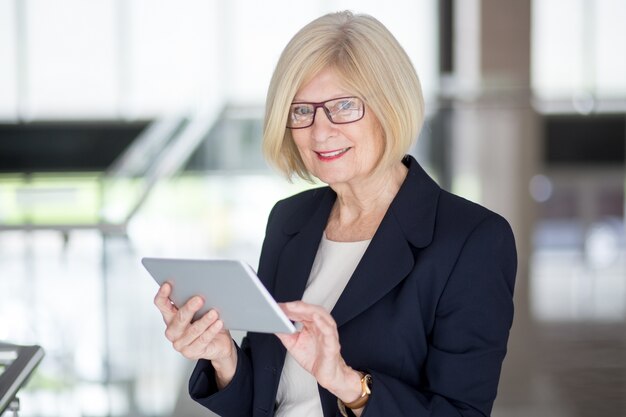 Une femme d&#39;affaires senior réussie utilisant le pavé tactile