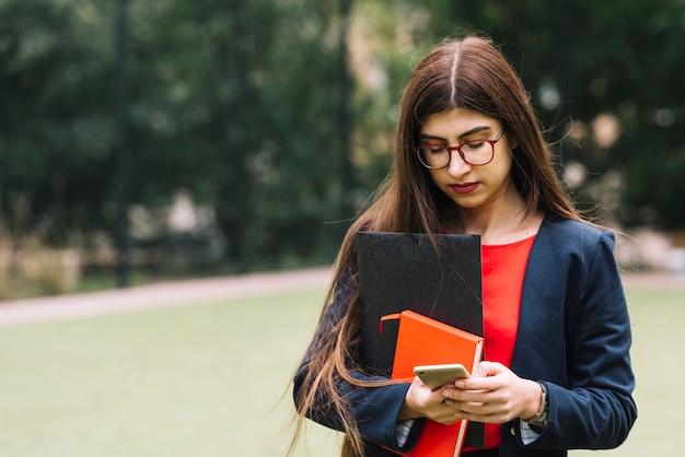 Photo gratuite femme d'affaires avec un smartphone à l'extérieur