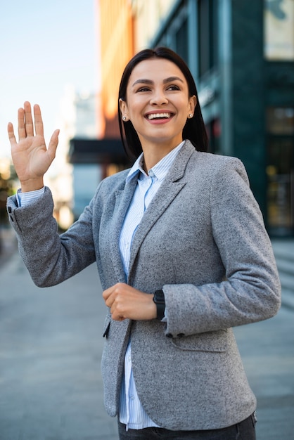 Femme d'affaires Smiley agitant dans la ville