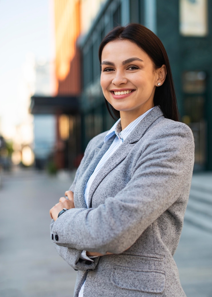 Photo gratuit femme d'affaires smiley posant dans la ville avec les bras croisés