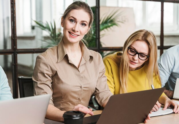 Femme d'affaires Smiley posant lors d'une réunion à l'intérieur