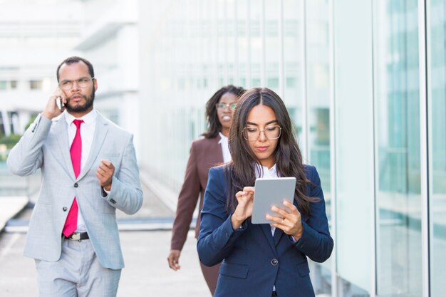 Femme d'affaires songeur sérieux avec tablette en marchant