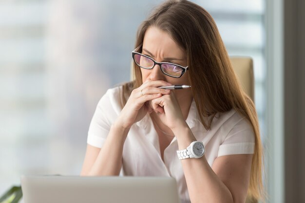 Femme d&#39;affaires songeuse réfléchissant au problème