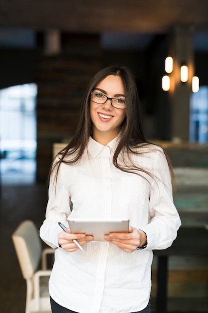 Photo gratuite femme d'affaires souriant avec tablette numérique