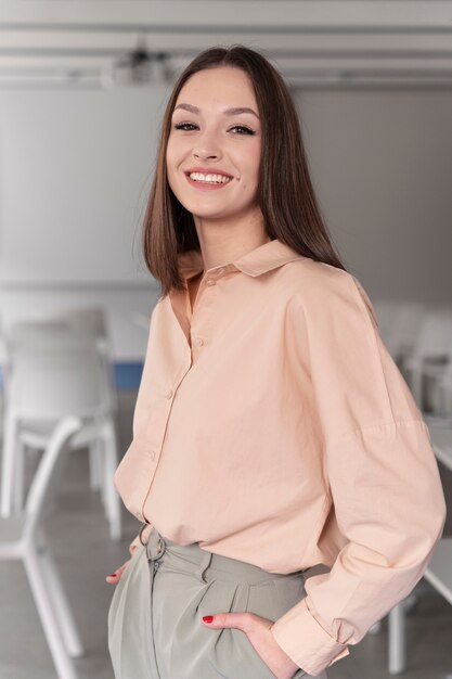 Femme d'affaires souriante posant au bureau