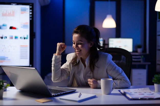 Une femme d'affaires stressée vérifiant les résultats des bénéfices debout dans un bureau