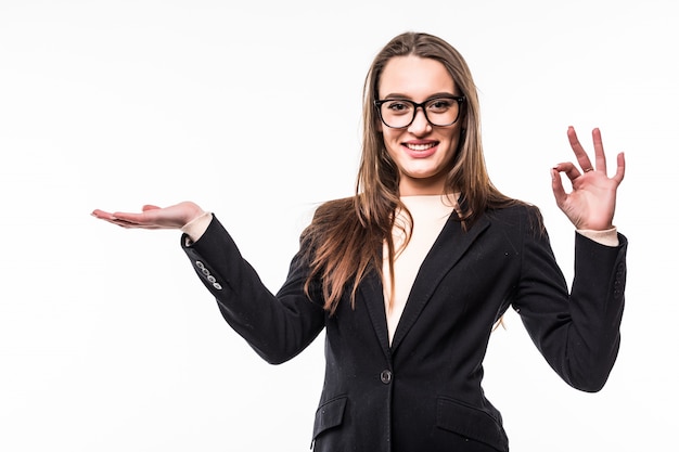 Femme d'affaires en suite noire classique sur blanc montre quelque chose avec la main