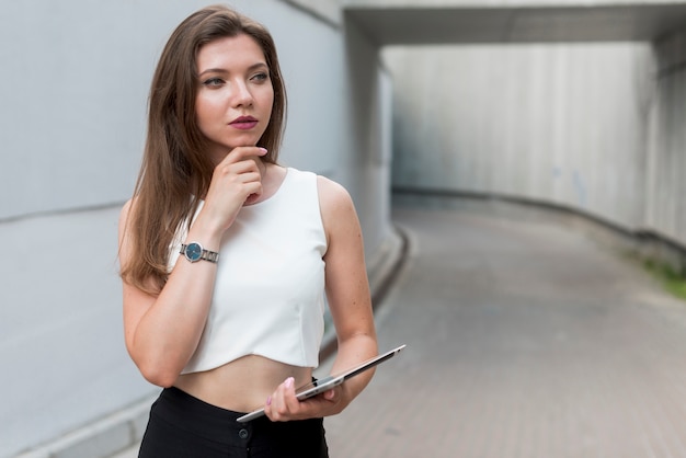 Photo gratuite femme d'affaires avec une tablette dans la rue