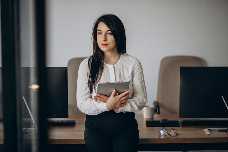 Photo gratuit femme d'affaires avec tablette debout au bureau
