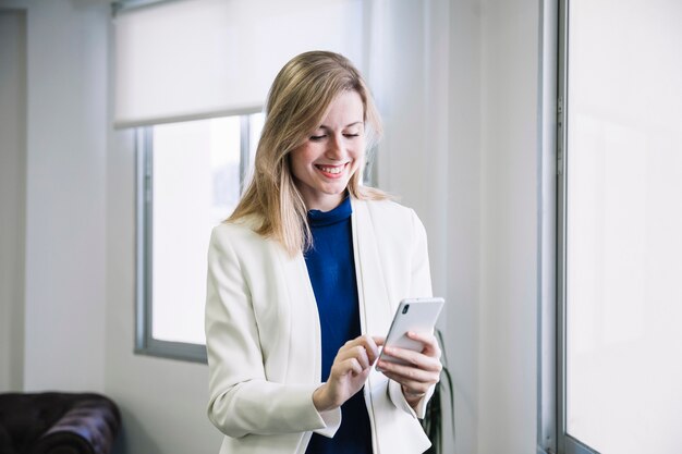 Femme d&#39;affaires en tapant sur smartphone