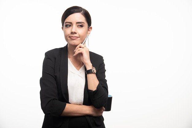 Femme d'affaires avec une tasse et un crayon sur fond blanc. photo de haute qualité