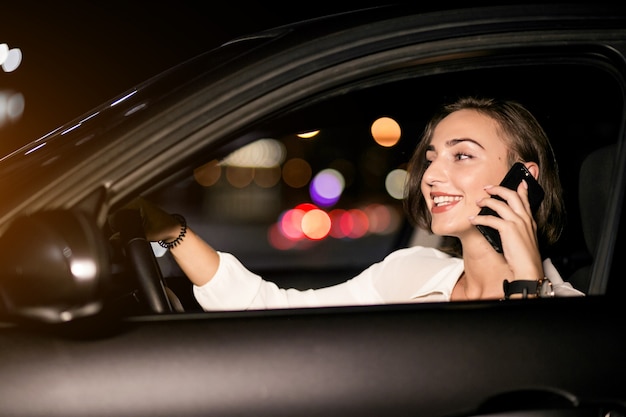 Femme d&#39;affaires avec le téléphone dans la voiture