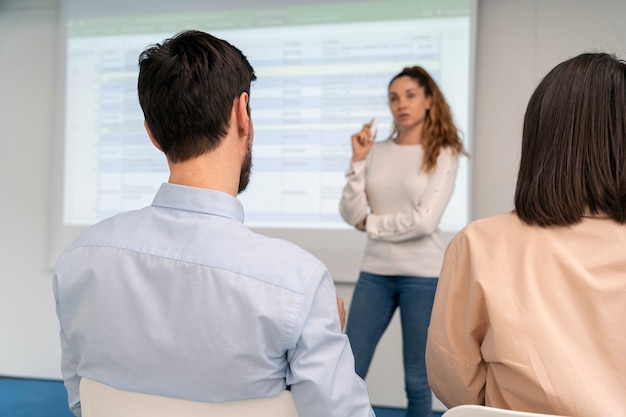 Photo gratuite femme d'affaires tenant une présentation au bureau pour ses collègues