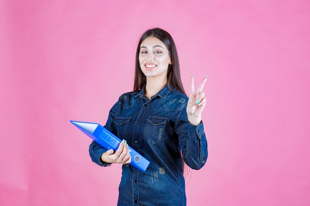 Femme affaires, tenue, a, dossier bleu, et, envoi, signe paix