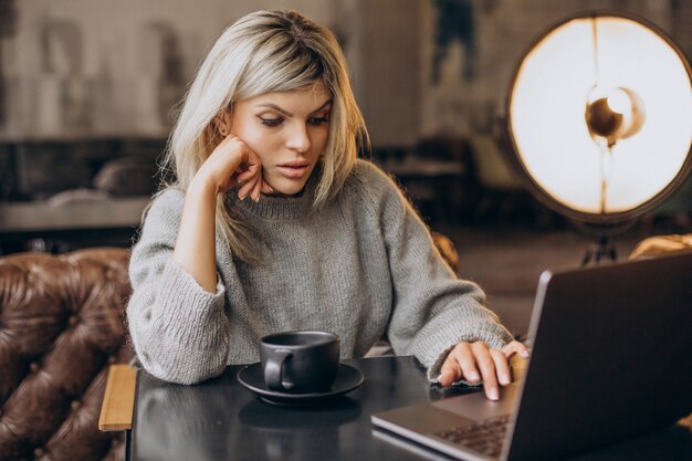 Femme d'affaires travaillant sur ordinateur dans un café