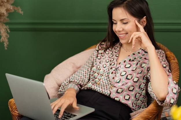 Femme d'affaires travaillant sur un ordinateur portable assis à la maison et gérant son entreprise via le bureau à domicile