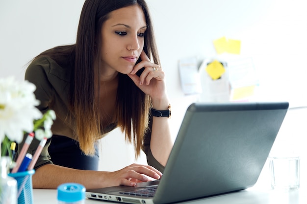 Femme d&#39;affaires utilisant son ordinateur portable dans le bureau.