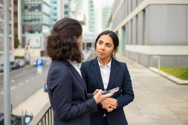 Femme affaires, utilisation, smartphone, regarder, collègues