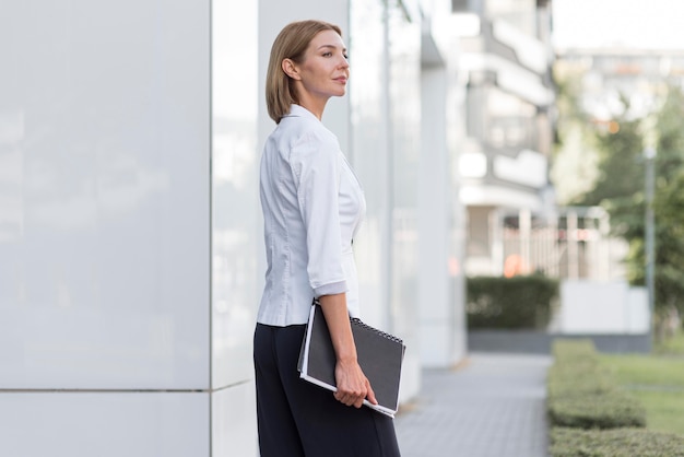 Femme d'affaires vue de côté avec fichier