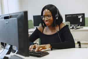 Photo gratuite femme africaine assise en classe d'informatique. dame à lunettes. étudiante assise à l'ordinateur.