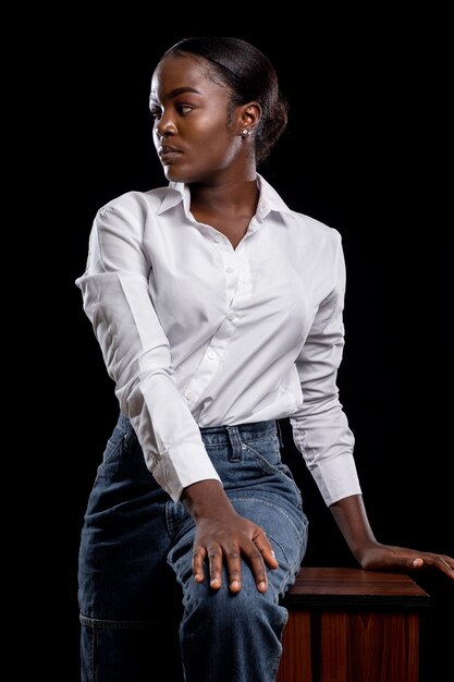 Femme africaine à la mode assis sur une table en bois