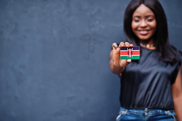 Une femme africaine tient un petit drapeau du Kenya dans les mains