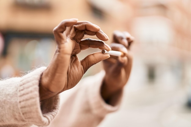 Photo gratuite femme afro-américaine cassant une cigarette dans la rue